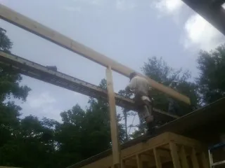 Carpenter setting a ridge beam over a new addition frame — Ice Dam Removal by Roofing Brothers in Lake Toxaway