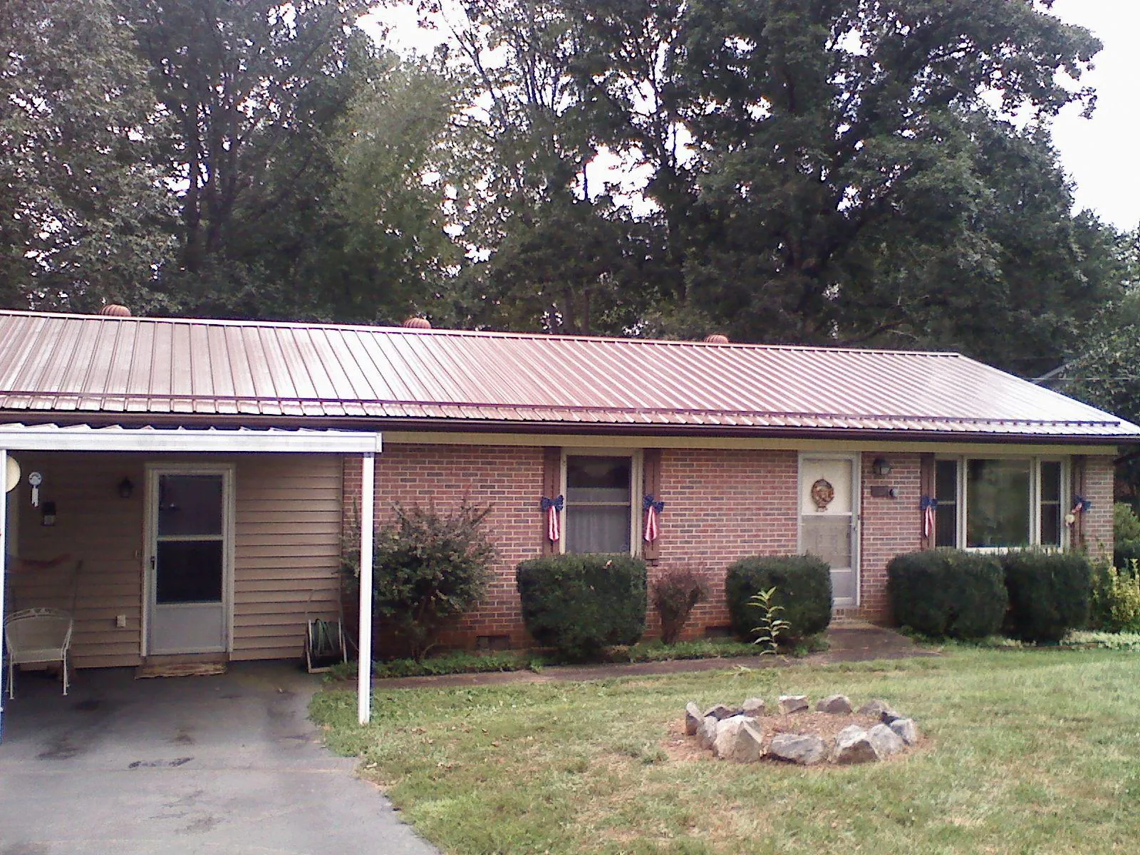 Bronze metal roof and carport on a brick ranch home — Roof Repair work by our crew in Lake Toxaway
