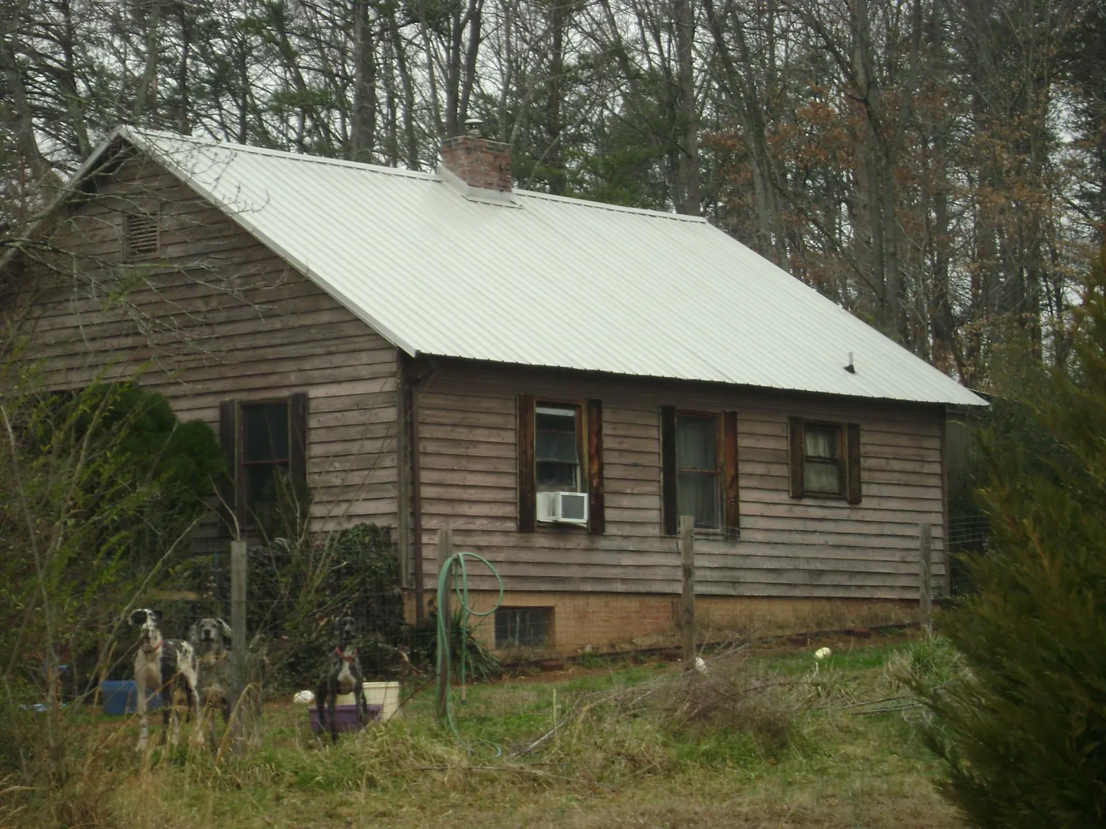 White metal roof on an old wood sided farmhouse, from a Asphalt Shingle Roof Repair job in Lake Toxaway